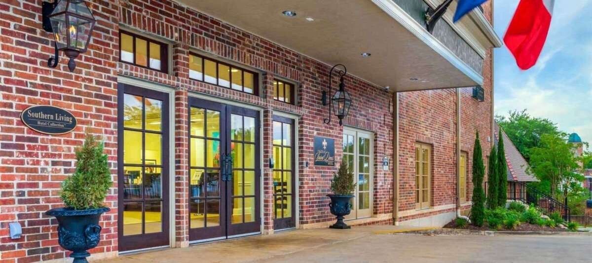 Brick building entrance with arched walkway and flags.